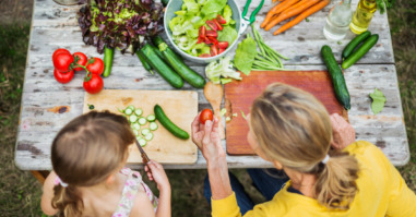 Mother And Daughter Preparing Salad