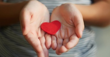Little girl holding a red heart