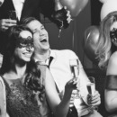 Laughing people in masks at party