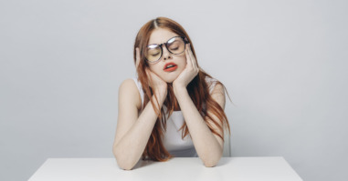 Frustrated Caucasian woman sitting at table