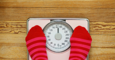 Pink striped socks standing on pink scale