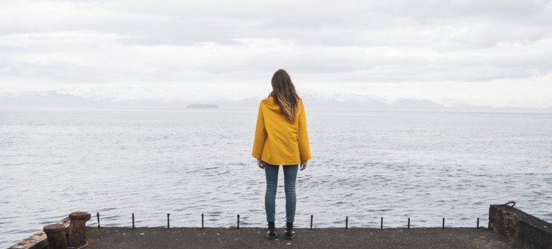 Iceland, woman standing at the sea