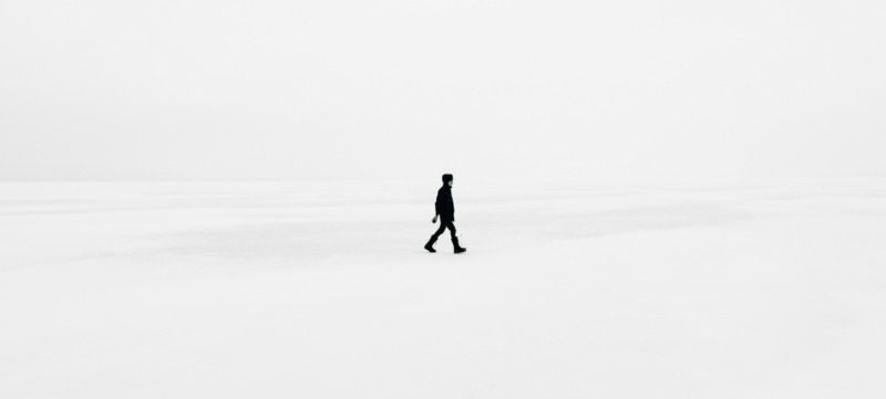 man loopt in een niemandsland als metafoor voor een simpeler leven
