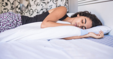 Teenage girl sleeping in bed