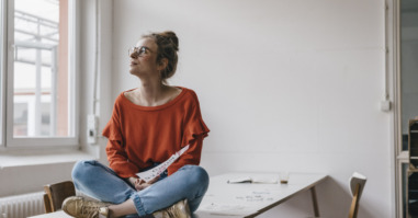 Young woman sitting on table thinking