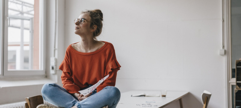 Young woman sitting on table thinking