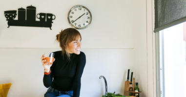 Young woman drinking fresh grapefruit juice in her kitchen