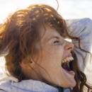 Redheaded woman enjoying fresh air at the beach