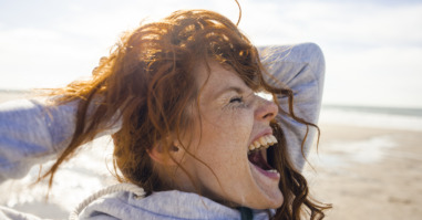 Redheaded woman enjoying fresh air at the beach
