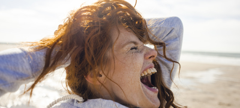 Redheaded woman enjoying fresh air at the beach