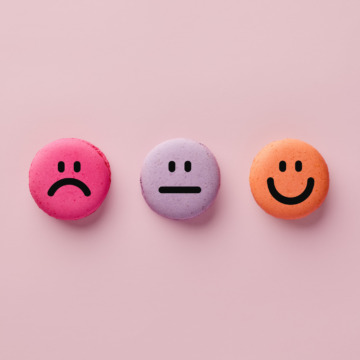 Colorful macarons with happy, neutral and sad faces. Customer rating and evaluation.