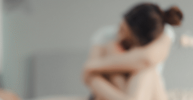 vrouw die in elkaar gedoken zit