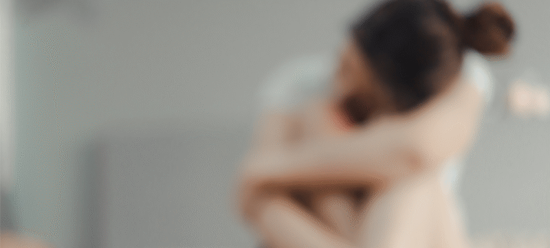 vrouw die in elkaar gedoken zit