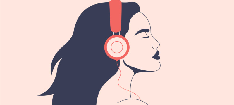 Confident woman listens to music with headphones. Girl with flying hair in earphones enjoying the sound.