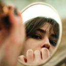 een vrouw die in de spiegel kijkt om lippenstift