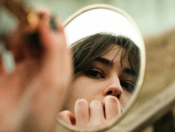 een vrouw die in de spiegel kijkt om lippenstift