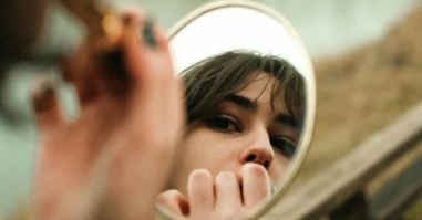 een vrouw die in de spiegel kijkt om lippenstift