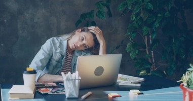 vermoeide vrouw achter laptop