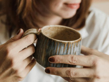 vrouw zit rustig van haar koffie te genieten zodat ze geen last heeft van overgangskalchten