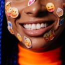 beeld van emoji's op gezicht van vrouw als beeld bij artikel over emoji-gebruik van mannen en vrouwen