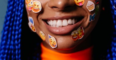 beeld van emoji's op gezicht van vrouw als beeld bij artikel over emoji-gebruik van mannen en vrouwen