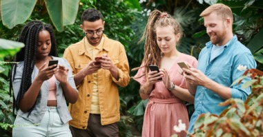 Vier personen op mobiel als beeld bij artikel social media