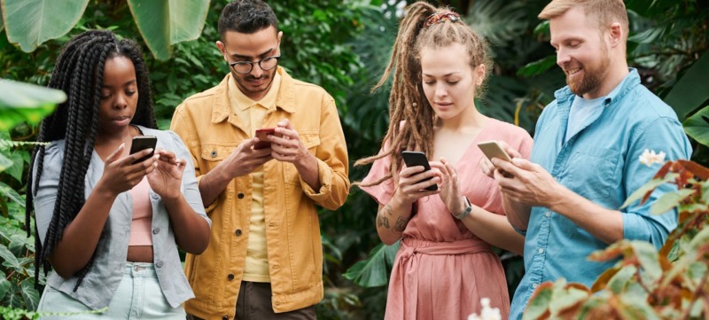 Vier personen op mobiel als beeld bij artikel social media