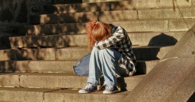 een persoon zit alleen op de trap en voelt zich eenzaam