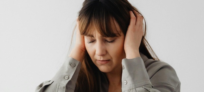 Vrouw die haar handen op haar oren houdt