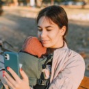 Moeder zit op haar telefoon waar haar baby bij is