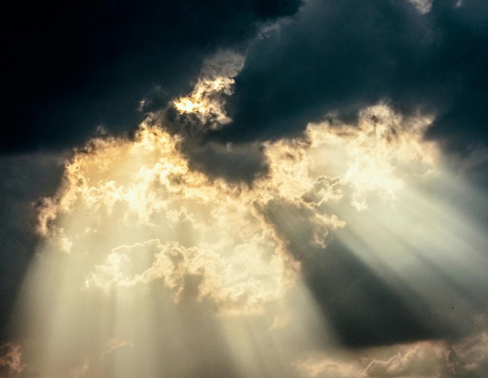 de zon schijnt door de donkere wolken heen