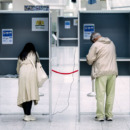 Mensen stemmen bij het stemhokje