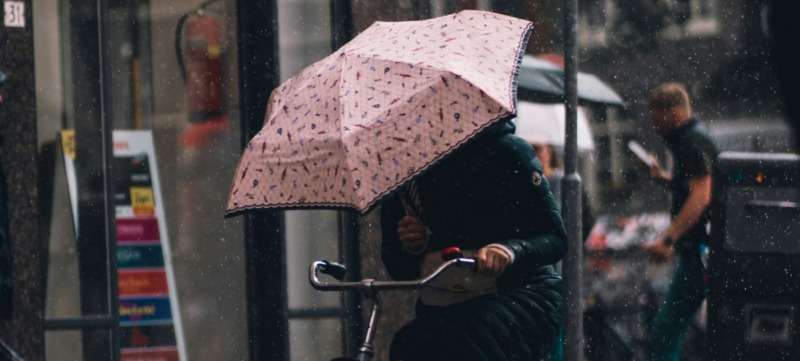 iemand fietst door weer en wind ter illustratie bij een artikel over winterdepressie