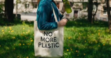 vrouw loopt met een canvas tasje met de tekst 'no more plastic'