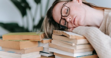 Een vrouw die moe is van lezen.