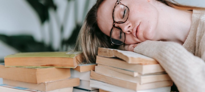 Een vrouw die moe is van lezen.