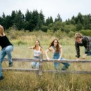 drie kinderen springen over een hek