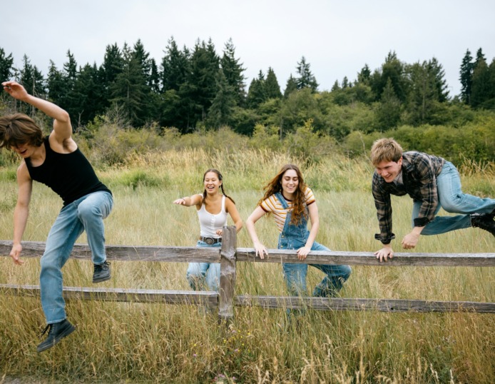 drie kinderen springen over een hek