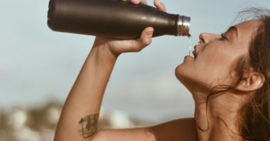 vrouw drinkt water uit een fles