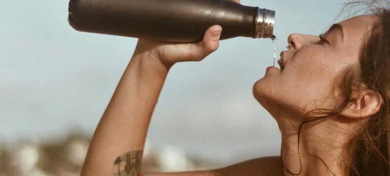 vrouw drinkt water uit een fles