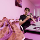 Jacob zittend aan zijn bureau met zijn telefoon in zijn hand, met een foto van Ava ingelijst op zijn bureau.