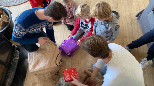 Kinderen pakken cadeautjes uit op pakjesavond.