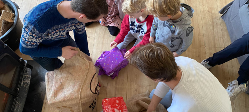 Kinderen pakken cadeautjes uit op pakjesavond.