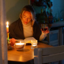 Een vrouw die een boek leest met kaarsjes op tafel