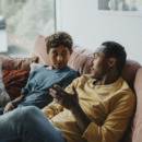 kind en ouder zitten op de bank en stellen elkaar goede vragen