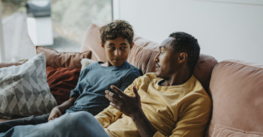 kind en ouder zitten op de bank en stellen elkaar goede vragen