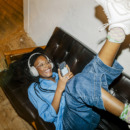 Vrouw die op de bank ligt en naar muziek luistert.