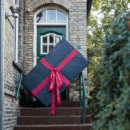 foto van een vrouw die een heel groot cadeau tilt