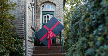 foto van een vrouw die een heel groot cadeau tilt