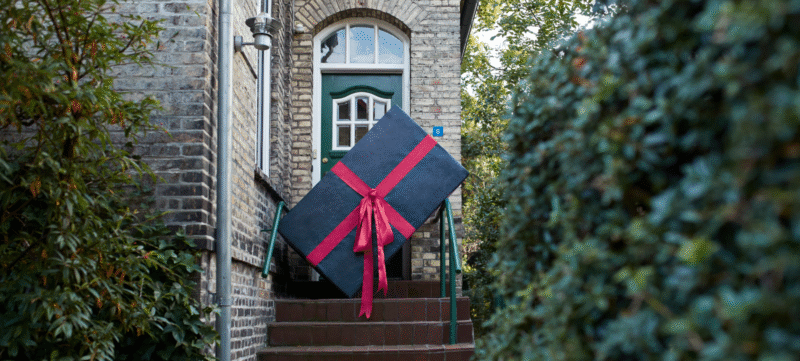 foto van een vrouw die een heel groot cadeau tilt
